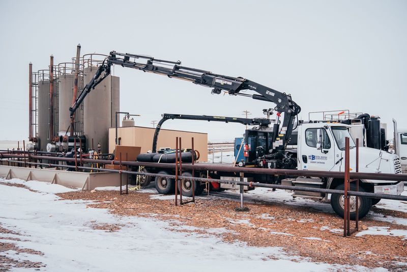 Elite crane truck set up alongside a tank battery
