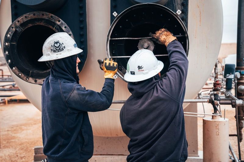 Elite technicians opening a heater treater on location